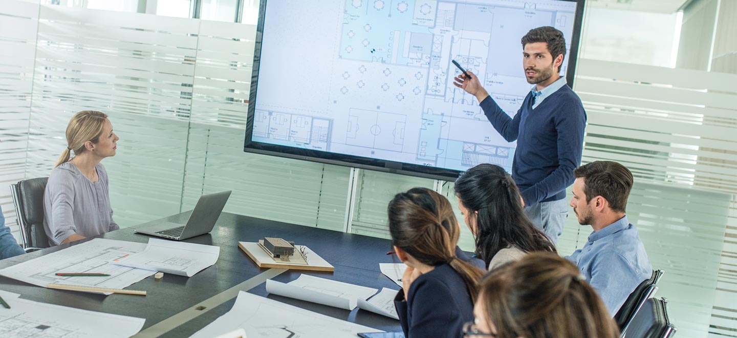 A young architect presenting his floor plans to his colleagues